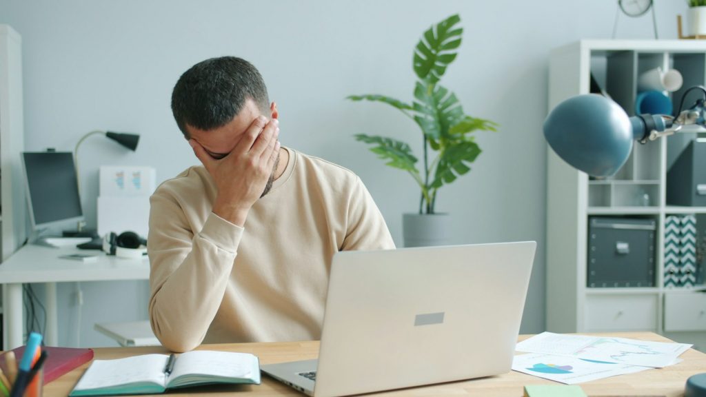 Dirigeant examinant des factures impayées, signal d'alerte pour sa gestion de trésorerie