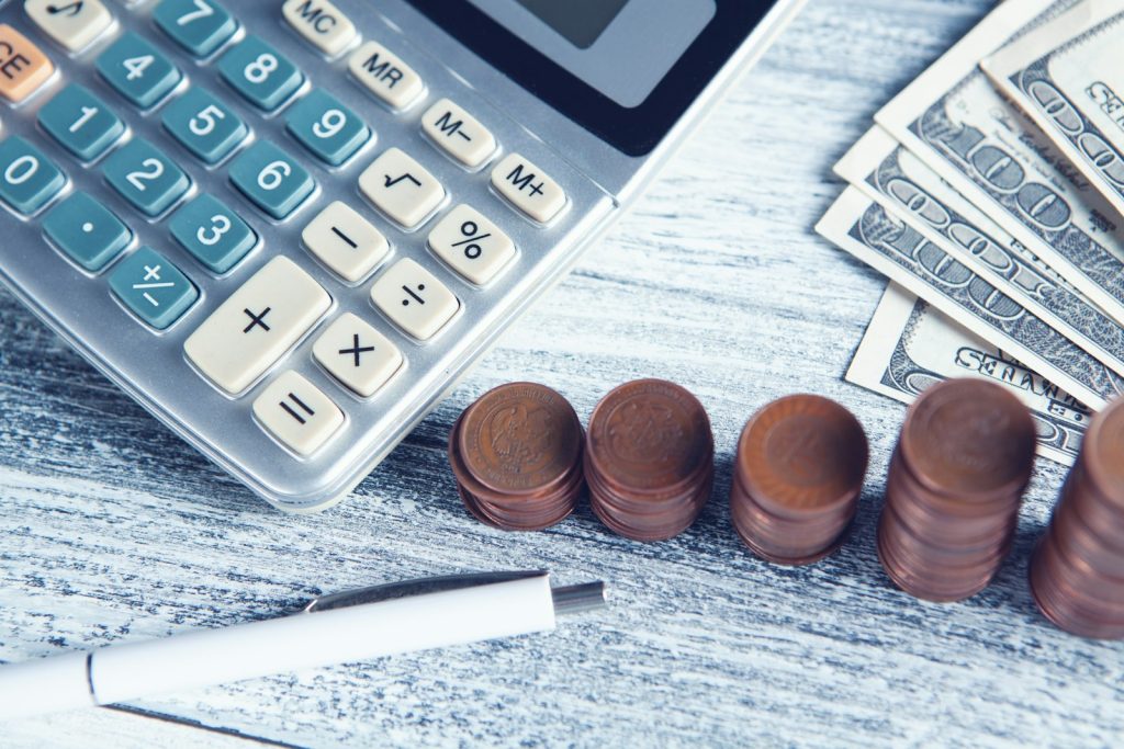 Calculatrice et pièces de monnaie pour estimer le coût de l'immatriculation d'une entreprise