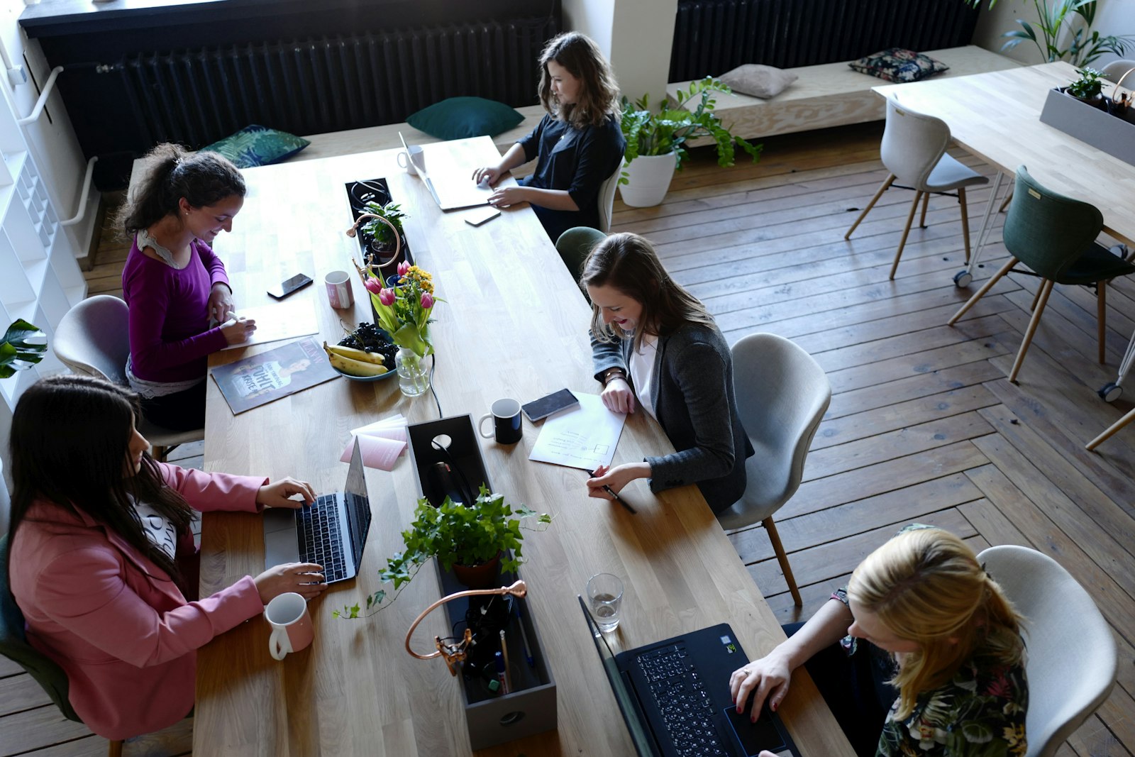 Professionnels travaillant sur leurs ordinateurs dans un espace de coworking lumineux