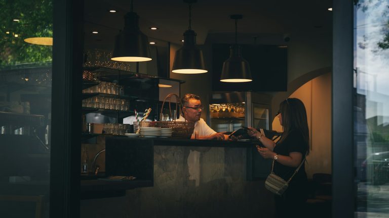 Gérante de café consultant ses comptes pour gérer sa trésorerie