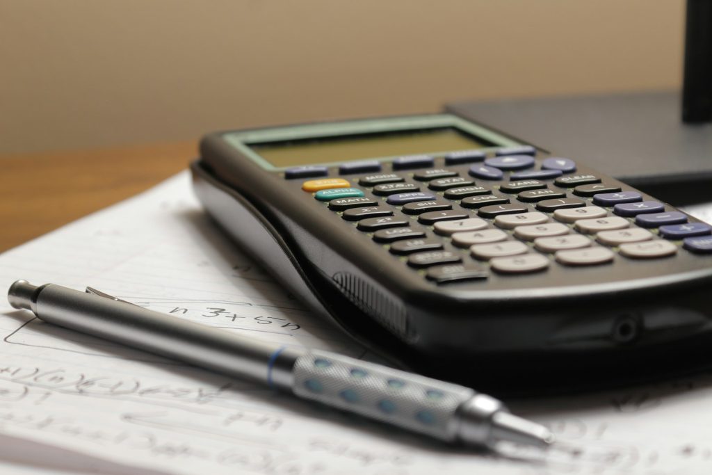 Calculatrice, clés et contrat de bail pour estimer le loyer d'un local commercial
