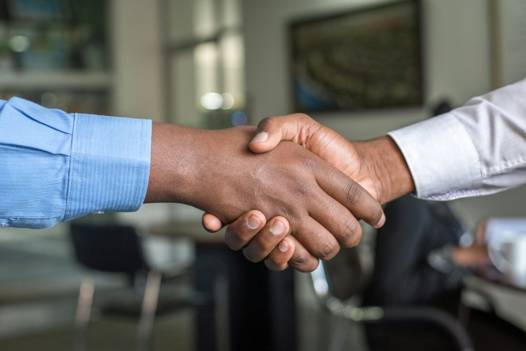 Deux associés se serrant la main après avoir choisi le statut juridique de leur société
